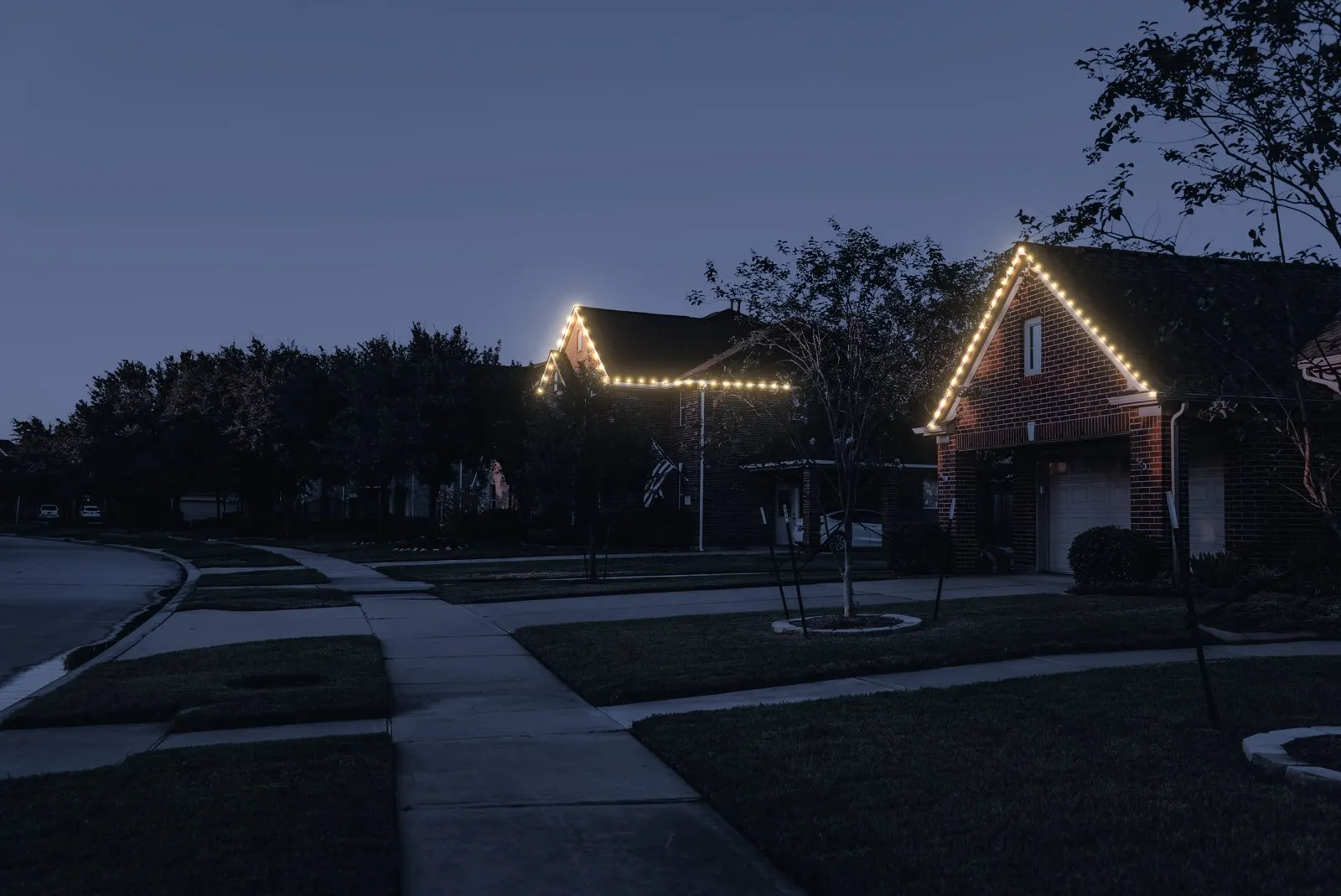 Visualization: Permanent eave lights on houses along a street at dusk